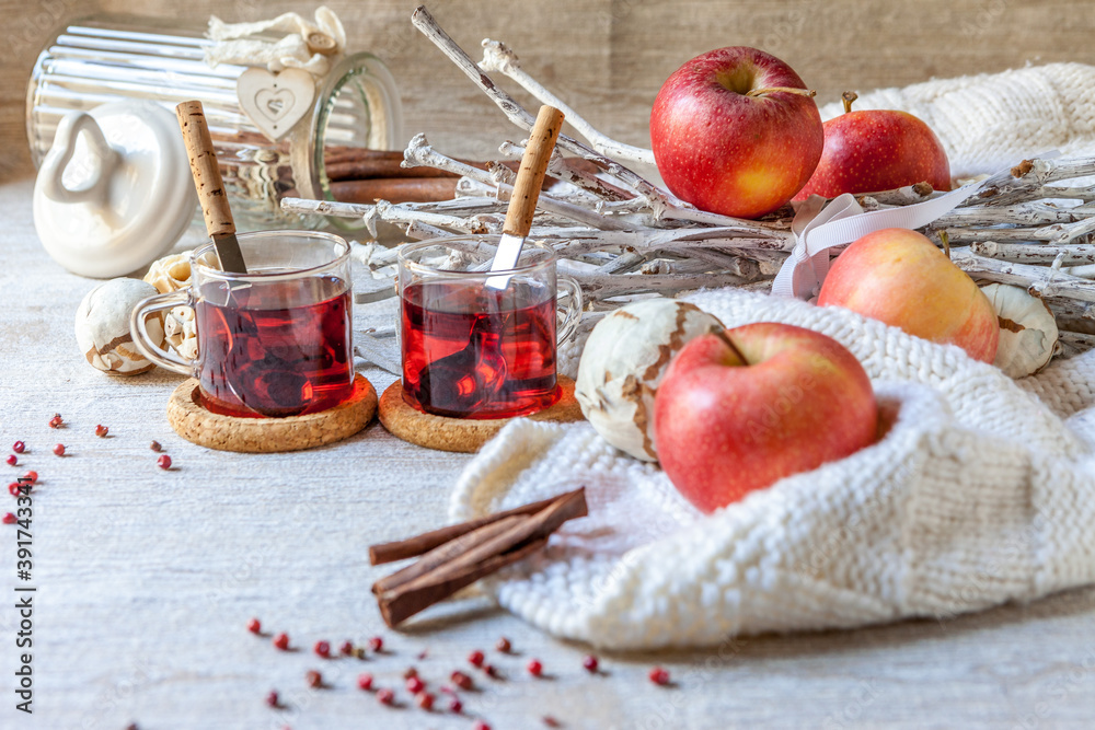 Cups of mulled wine with cinnamon red apples and white decoration