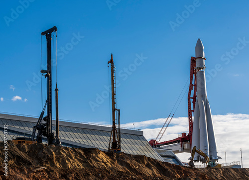 Fototapeta Naklejka Na Ścianę i Meble -  construction machinery and architectural engineering on a construction site, cran and drilling rig on a building rocket launch facility