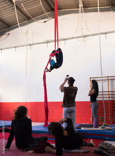 Demonstration of exercise in aerial silks to the group of students of the circus school