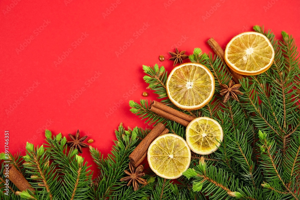 Fir tree branches, dried orange slices and spices on red background. Fir tree branches, dried orange slices and spices on red background.