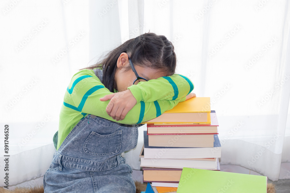 Adorable Asian girl pay attention looking to stack of books, elementary school girl worry to reading book or get headache, kid in casual unhappy or boring sleep on stack of books learning at home Adorable Asian girl pay attention looking to stack of books, elementary school girl worry to reading book or get headache, kid in casual unhappy or boring sleep on stack of books learning at home