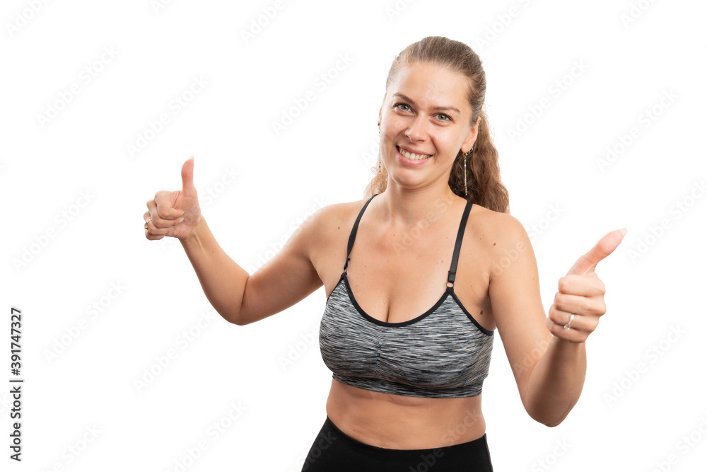 Friendly female model in gym attire showing double like gesture Friendly female model in gym attire showing double like gesture