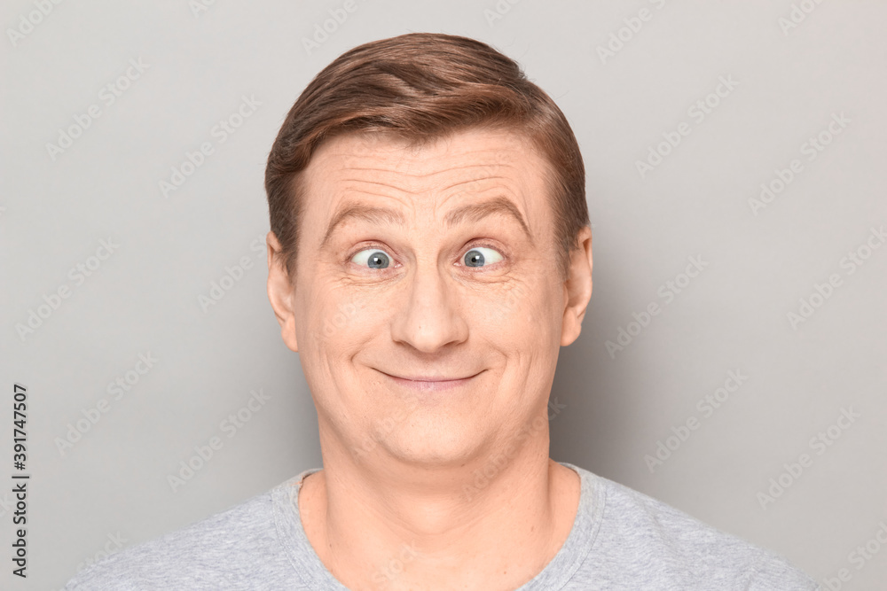 Portrait of funny happy man making goofy face with crossed eyes - obrazy, fototapety, plakaty 