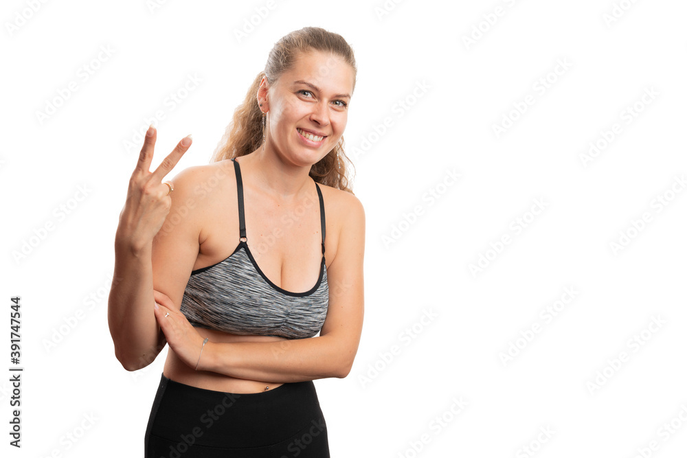 Smiling woman wearing gym attire making number two gesture Smiling woman wearing gym attire making number two gesture