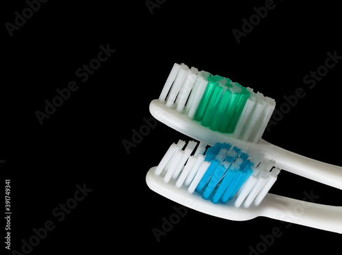 two new toothbrushes, close-up isolated on black