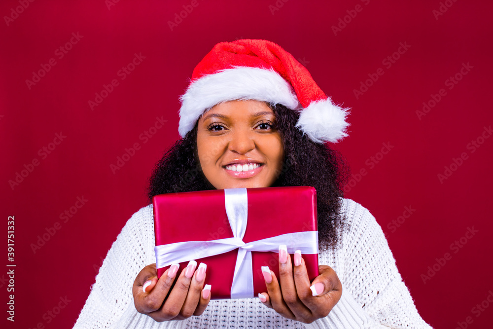 joyful pretty woman in red santa claus hat laughing isolated on red background she is happy and excited full of fun holding gift box joyful pretty woman in red santa claus hat laughing isolated on red background she is happy and excited full of fun holding gift box