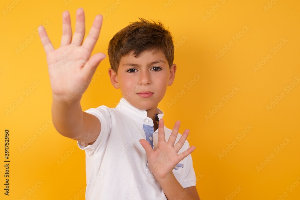 Portrait of smiling Cute Caucasian little boy standing against yellow background looking at camera and gesturing finger frame. Creativity and photography concept. Portrait of smiling Cute Caucasian little boy standing against yellow background looking at camera and gesturing finger frame. Creativity and photography concept.