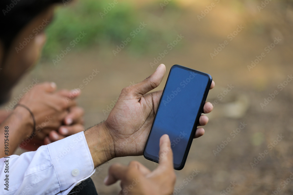 Young indian agronomist or banker showing some information to farmer in smart phone