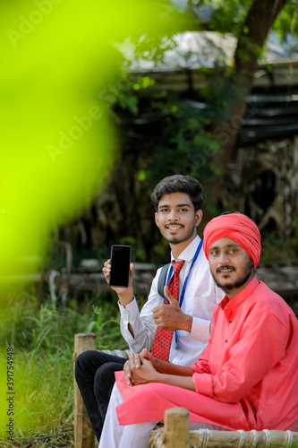 Young indian bank officer showing mobile screen with farmer © PRASANNAPIX