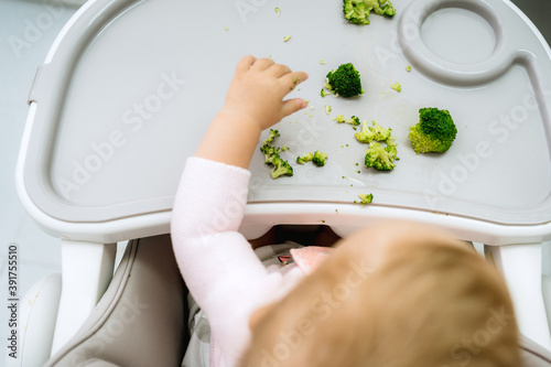 Baby led weaning concept, adorable caucasian blonde girl, vegetarian dieting approach