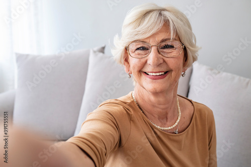 Grandma Taking Selfies at Home in the Livingroom. Close Up Portrait of Happy Cheerful Delightful Charming Beautiful Elderly Lady Granny Grandma Taking a Selfie. Old-Age, Retirement and People Concept