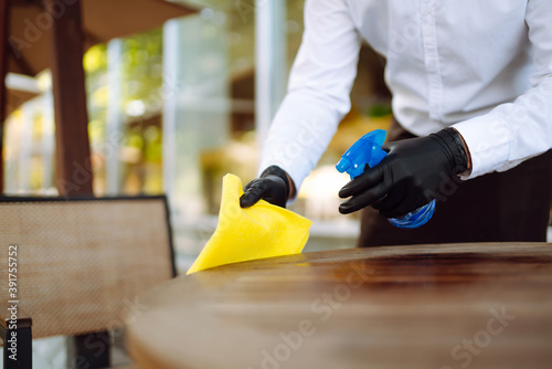 Obraz na płótnie Sanitizing surfaces cleaning  table with disinfectant spray bottle washing surface with towel and gloves