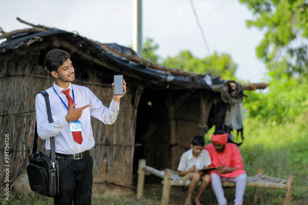 Young indian bank officer showing mobile screen with farmer Young indian bank officer showing mobile screen with farmer