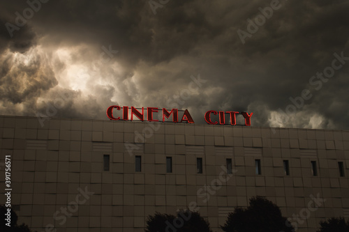 Canvas Print Cinema building, movies, dramatic clouds as background