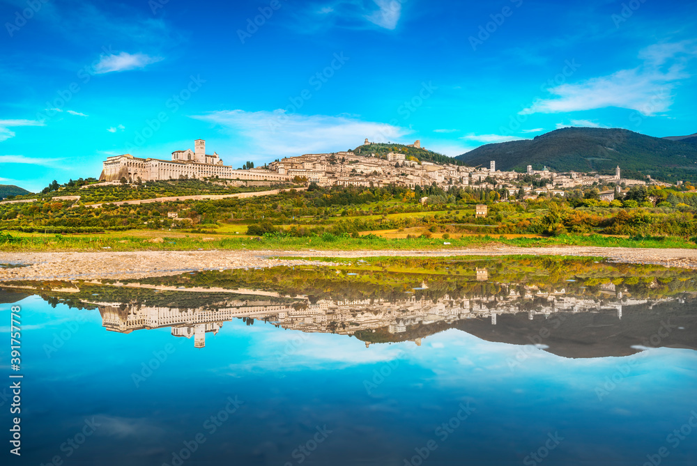 Assisi town skyline and reflection on the water. Perugia, Umbria, Italy.