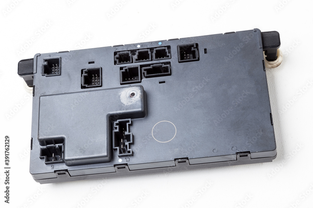 A stripped part with a connector from a car on a white isolated background is a plastic electronic control unit for replacement and repair. Spare parts catalog for sale. A stripped part with a connector from a car on a white isolated background is a plastic electronic control unit for replacement and repair. Spare parts catalog for sale.