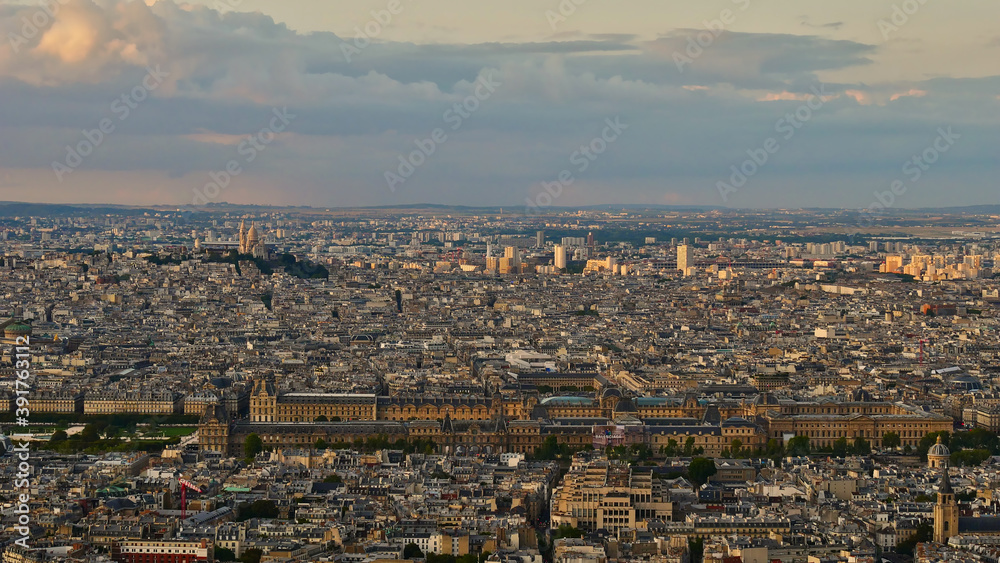 Stunning panorama view over the northern historic city center of Paris, France with Louvre Museum complex and Sacre-Coeur cathedral located on Montmarter hill in the beautiful evening light in fall.