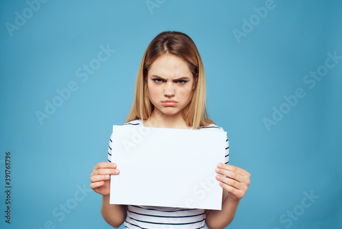 Emotional woman holding a sheet of paper in her hands lifestyle close-up blue background Copy Space