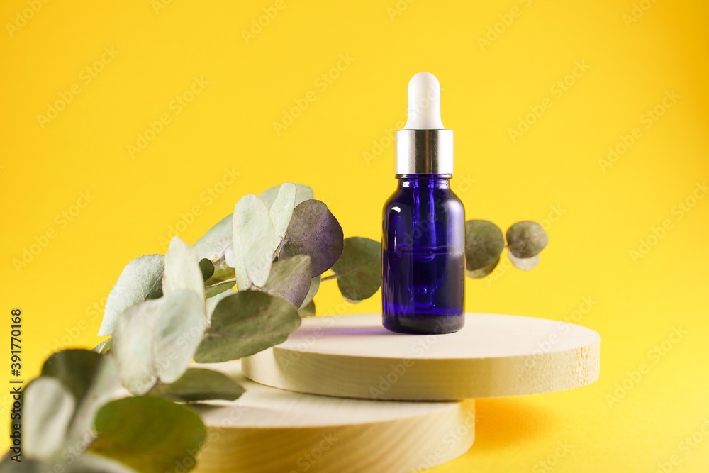 Blue liquid bottle on a wooden podium Blue liquid bottle on a wooden podium