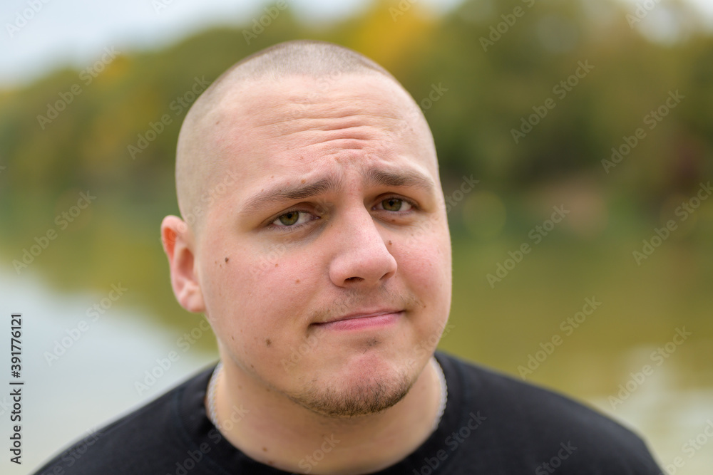 Fototapeta premium Close up head shot of a thoughtful young man