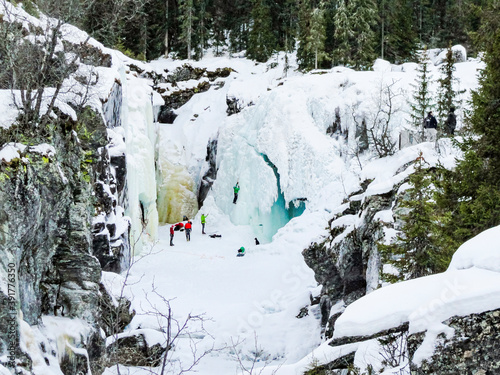 Ice climbers mountaineers climb up frozen waterfall Rjukandefossen, Hemsedal, Norway. photo