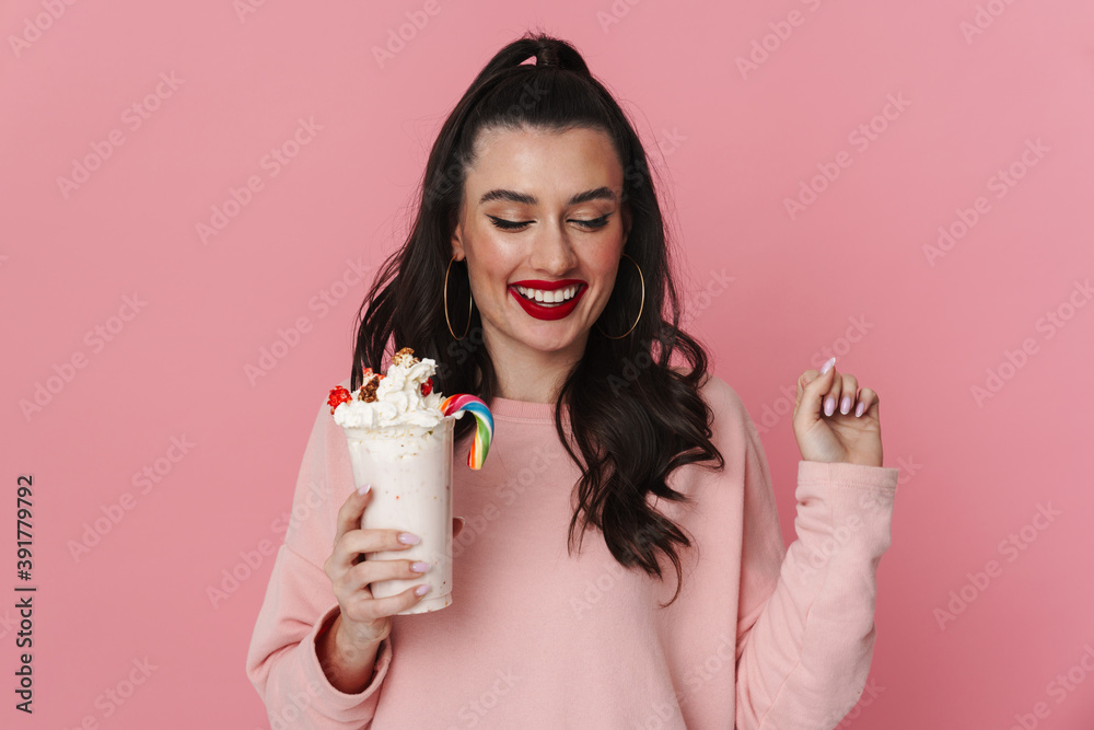 Happy beautiful brunette girl smiling while posing with milkshake Happy beautiful brunette girl smiling while posing with milkshake