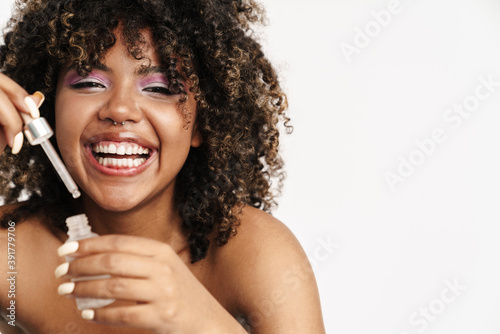 Beautiful laughing african american girl applying facial serum