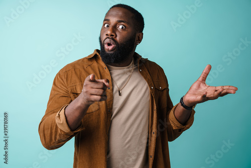Confused african american man looking aside and showing copyspace