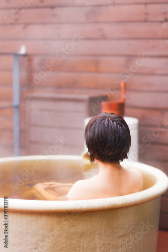 Japanese woman taking outdoor bath 