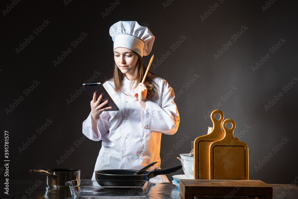 Cook looks at tablet. Chef uses gadget. Concept chef reads recipes
