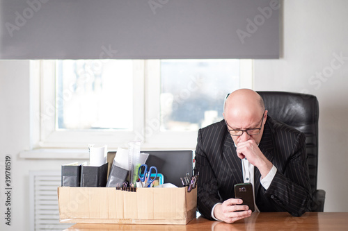 Dismissed man looks at phon...