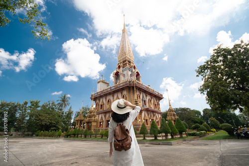 Woman tourist is traveling and sightseeing in Wat Chalong or Chalong Temple is the biggest and most visited temple on Phuket Island, Thailand.