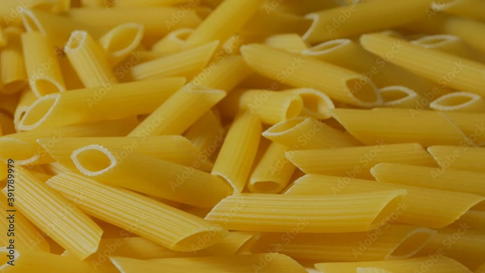 Lots of penne pasta close-up rotates top view. Production of pasta. 4k Lots of penne pasta close-up rotates top view. Production of pasta. 4k