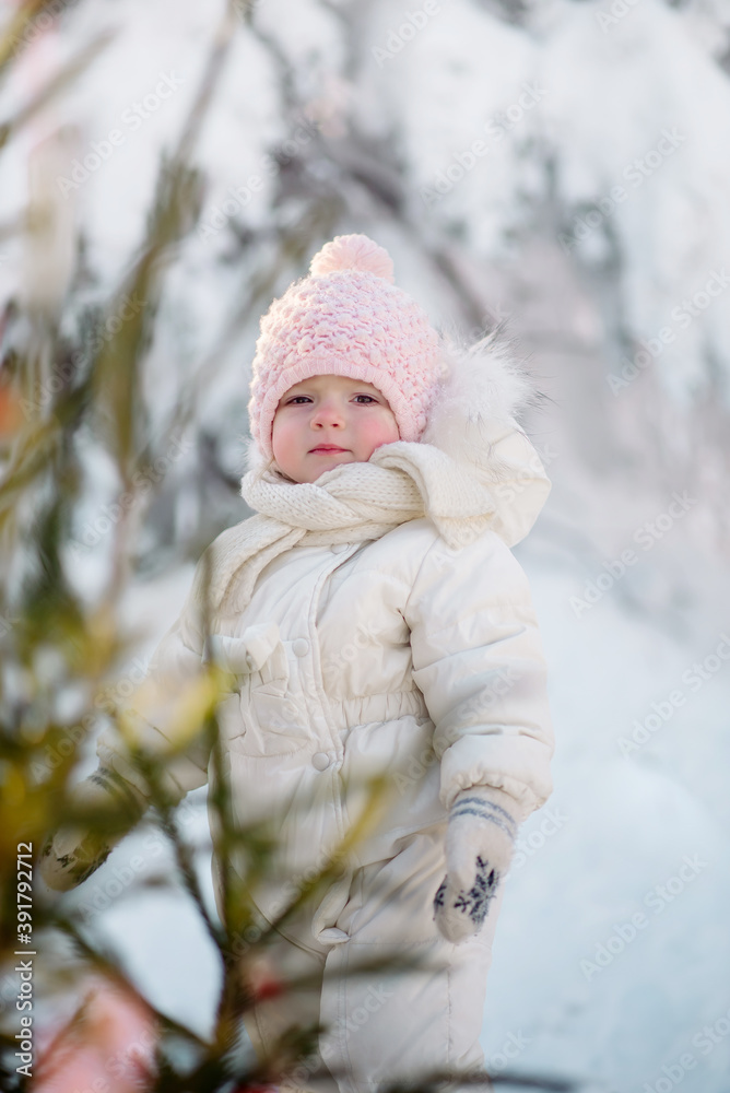 Little girl toddler in warm clothes walks in the winter forest against the background of New Year's decorations
Little girl toddler in warm clothes walks in the winter forest against the background of New Year's decorations