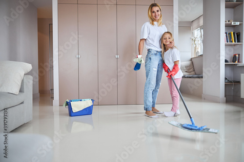 Mom and child smiling and looking at camera in clean living room