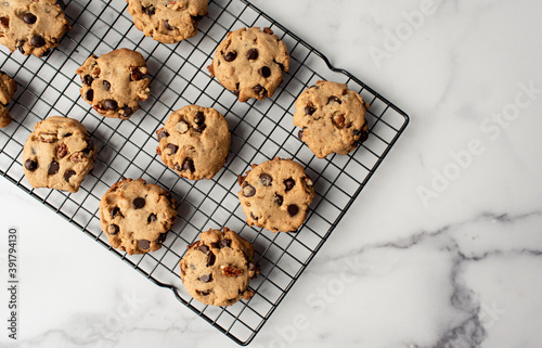 Overhead view of freshly baked chocolate chip cookies on cooling rack. photo