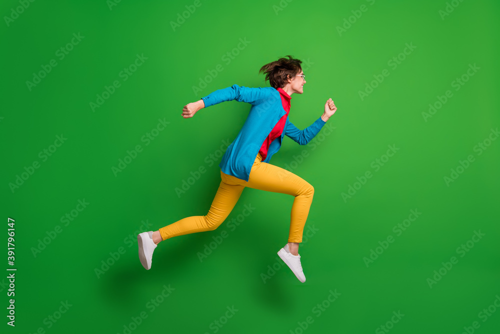 Full length body size side profile photo of jumping high hurrying up running girl isolated on vivid green color background Full length body size side profile photo of jumping high hurrying up running girl isolated on vivid green color background