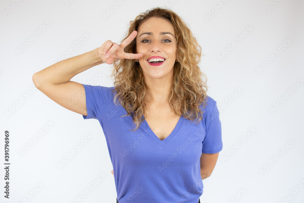 Young beautiful woman wearing casual t-shirt over white isolated background doing peace symbol with fingers over face, smiling cheerful showing victory Young beautiful woman wearing casual t-shirt over white isolated background doing peace symbol with fingers over face, smiling cheerful showing victory
