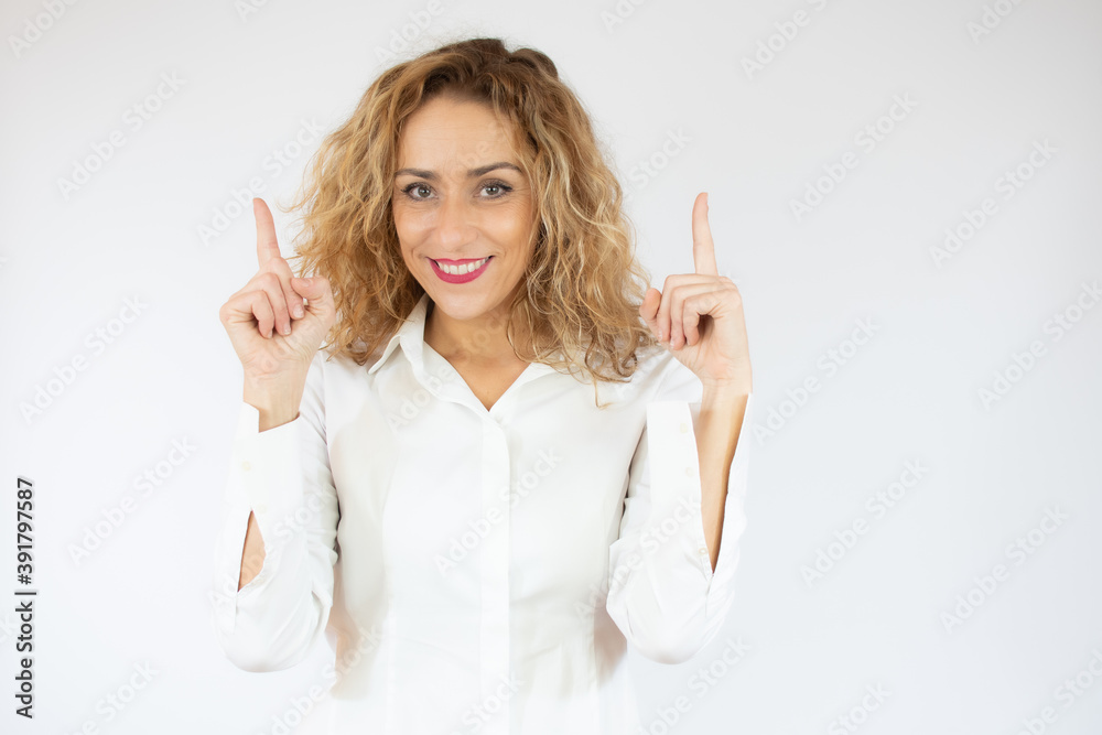 Smiling business woman pointing up and looking at the camera over white background Smiling business woman pointing up and looking at the camera over white background