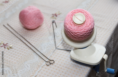 Process of winding pink wool yarn from tangle to winding, using a coiler photo