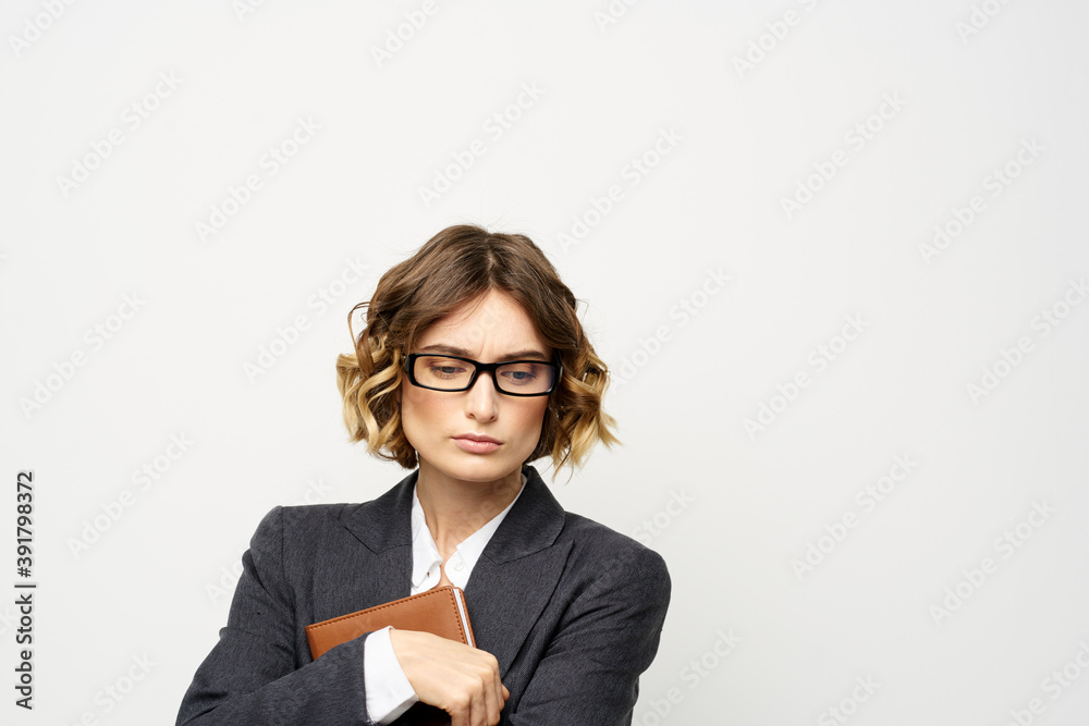 Business woman with notepad and glasses work light background cropped view of suit model. Business woman with notepad and glasses work light background cropped view of suit model.