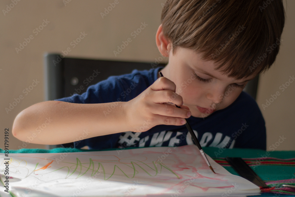 A little boy painting on paper with a brush. Indoors, close shot.
A little boy painting on paper with a brush. Indoors, close shot.