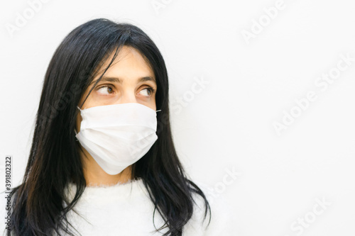 Close up of Young caucasian woman wearing white mask and looking to the right side of white blank space area.