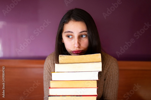 Stressed woman with a pile of books. photo