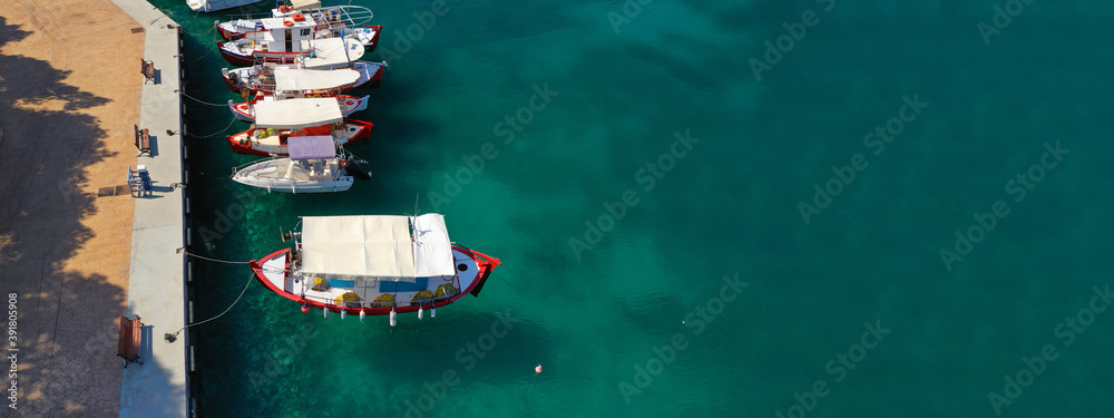 Aerial drone ultra wide photo of traditional fishing boats in small fishing port and village of Votsi in island of Alonissos, Sporades, Greece