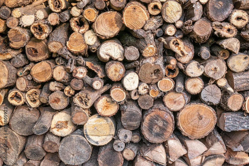 The surface background of tree piled up with firewood for heating in winter. The surface background of tree piled up with firewood for heating in winter.
