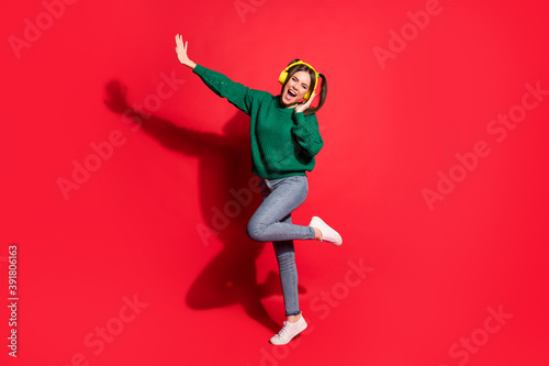 Full size photo of young attractive crazy excited smiling girl listen music in yellow headphones isolated on red color background