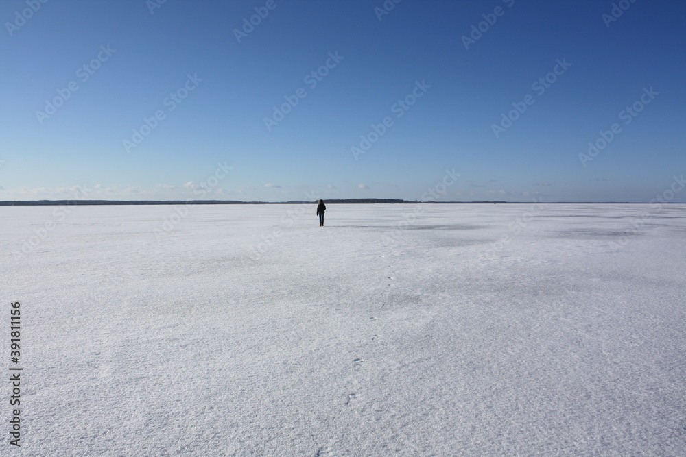 Person walking on frozen lake in winter