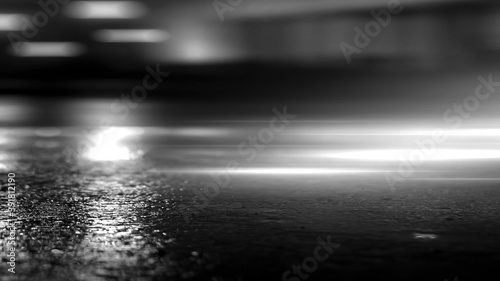 Dark street  black background  glare of light on the wet asphalt. Rays and lines  smoke. Dark city street.