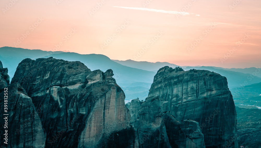 Sunset view over unique rock formations and mountains in Meteora, Greece